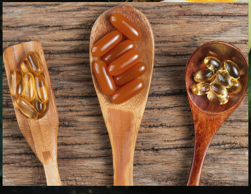 Herbal supplement capsules on wooden spoons